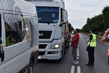 Przedstawiciel kampanii wręcza kierowcy materiały informacyjne kampanii