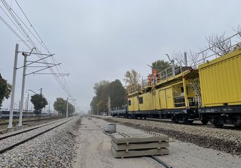 Wykonawcy wieszają nową sieć trakcyjną na przystanku Warszawa Grochów, widać pociąg trakcyjny, fot. Anna Znajewska-Pawluk