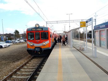 Tuchów - na peronie są podróżni, obok stoi pociąg, fot. Jerzy Lebda