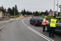 Samochody przed zamkniętym przejazdem. Kierowcy otrzymują materiały od sokisty i koordynatorki kampanii.