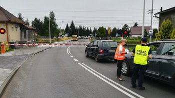 Samochody przed zamkniętym przejazdem. Kierowcy otrzymują materiały od sokisty i koordynatorki kampanii.
