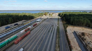Stacja Siemianówka, wagony towarowe stoją na stacji, w oddali Zalew Siemianówka; aut. Paweł Mieszkowski
