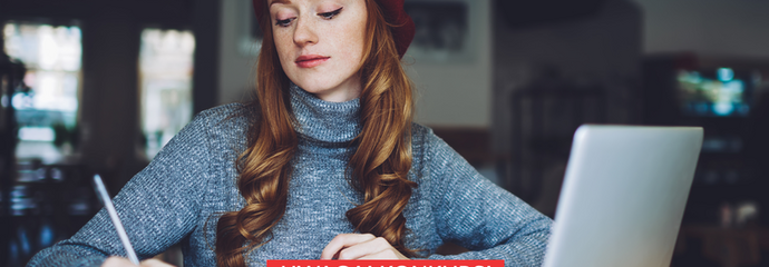 Kobieta przy laptopie, pisze opowiadanie w zeszycie