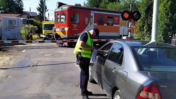 Pociąg na zamkniętym przejeździe, Sokista wręcza ulotkę kierowcy w samochodzie