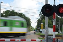 Pociąg w ruchu na przejeździe z zamkniętymi rogatkami