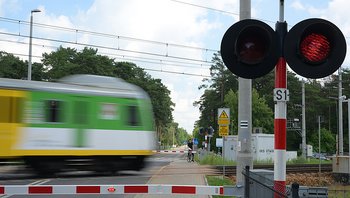Pociąg w ruchu na przejeździe z zamkniętymi rogatkami