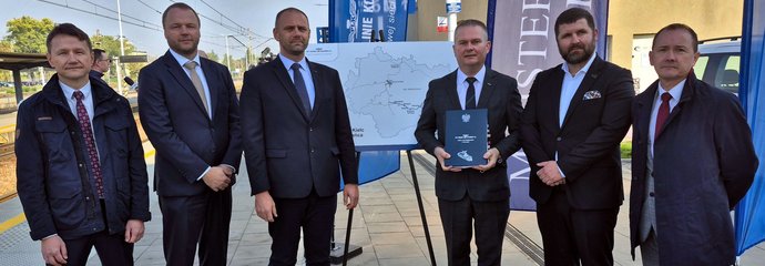 Uczestnicy wydarzenia prezentującego podpisanie umów na budowę sześciu nowych przystanków kolejowych przy liniach kolejowych nr 70 i 75.