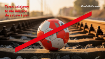 Przekreślona piłka leżąca na torach kolejowych