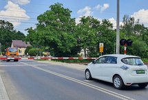 Przejazd kolejowo-drogowy zamkniętymi rogatkami. Samochody przed szlabanem.