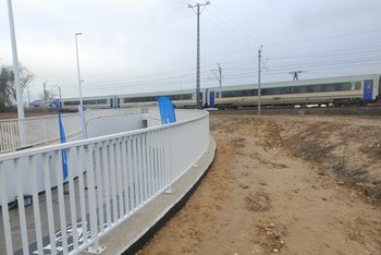 Pociąg przejeżdżający nad nowym przejściem w Kiekrzu, z przodu barierki tunelu_fot.Radek Śledzińsk